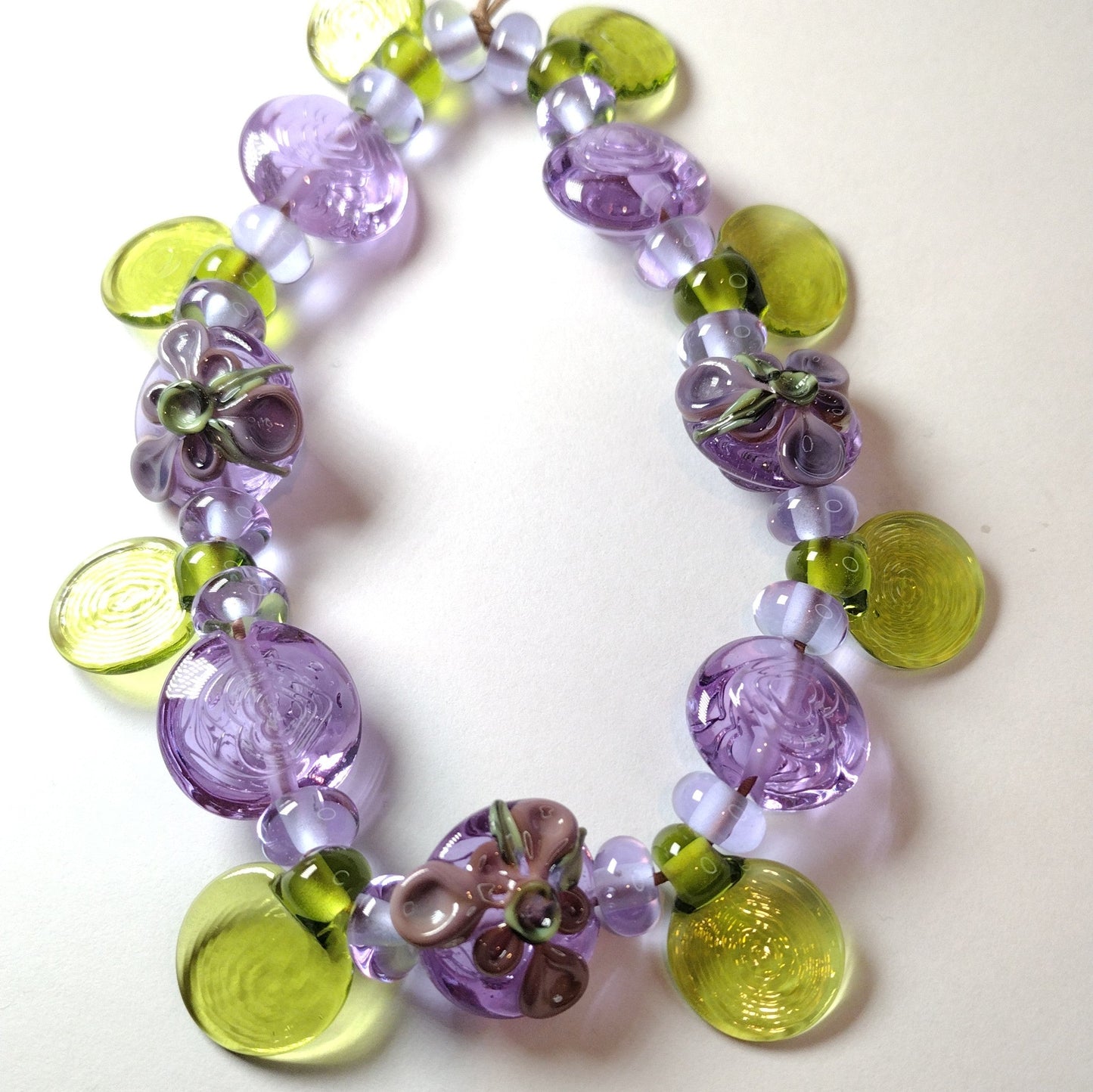 Large set of lilac flower and heart themed lampwork beads Jolene Beads