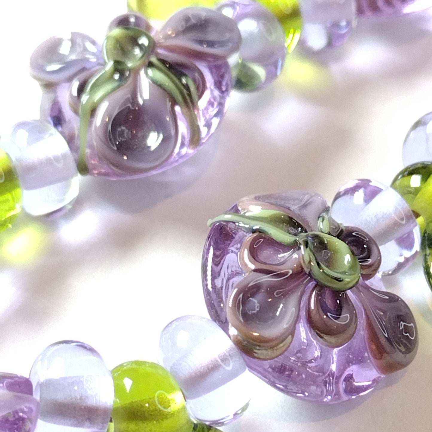 Large set of lilac flower and heart themed lampwork beads Jolene Beads