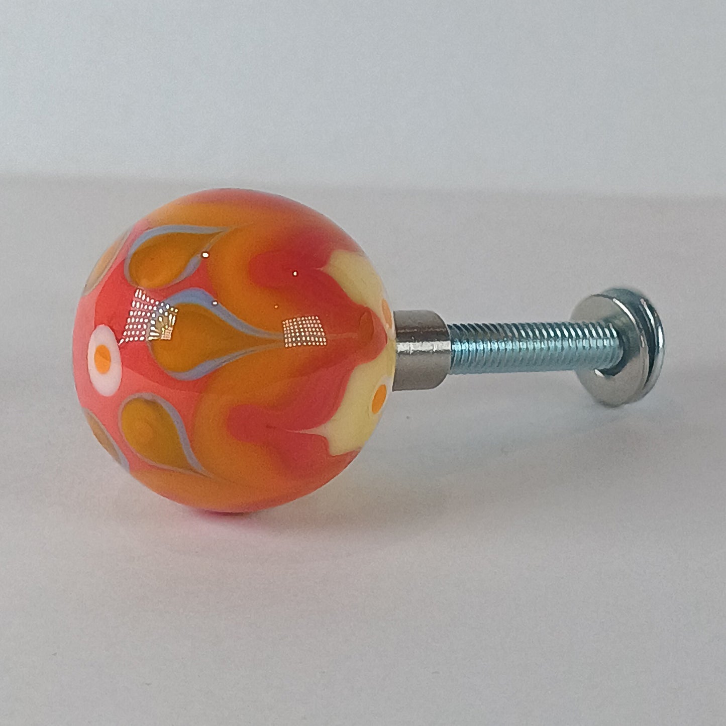 Decorative glass draw knob with orange and blue patterns